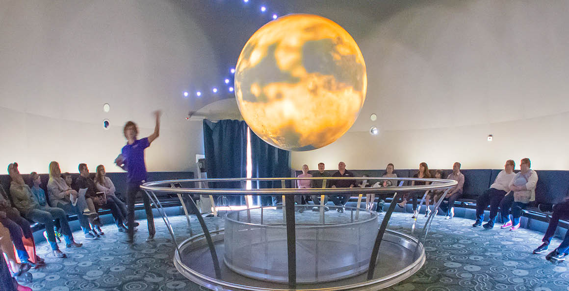 This image shows Science on a Sphere, which is a sphere suspended from the ceiling that different information can be projected onto. This sphere is one of the many things to do in Science City, and is always a crowd favorite.