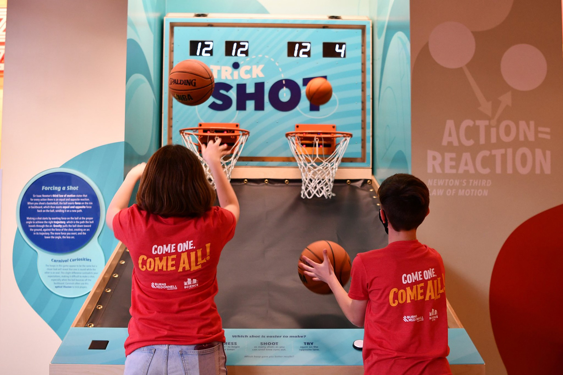 two kids shooting basketballs into hoops